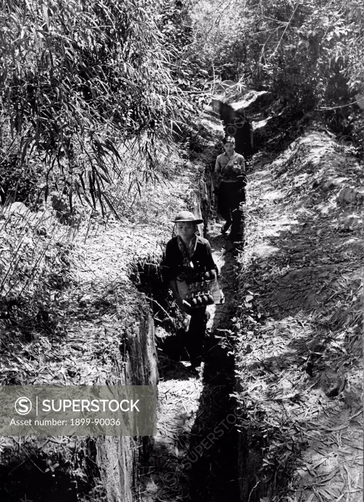 South Vietnamese villagers, Communist guerrillas, carrying grenades in a trench. Viet Cong. Vietnam War. 1966.