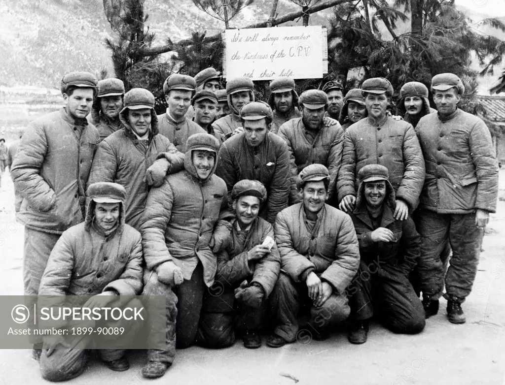 Korean War. A happy group of American prisoners in a North Korean POW camp. 1953. The sign behind them reads: 'We will always remember the kindness of the C.P.V. (Chinese People's Volunteers) and their help.'