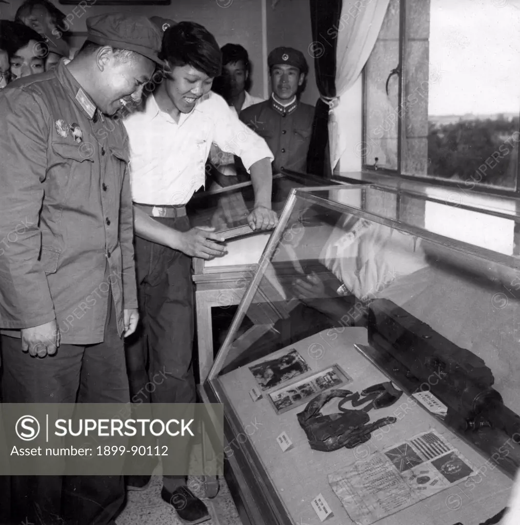 June 22, 1960. Resist US Aggression, Aid Korea exhibition opens in Peking. Chang Chi-hui, combat hero of the air force of the former Chinese People's Volunteers, inspects the aeronautical chart and weapons used by the so-called US trump card pilot Davis who was shot down by him in the war to resist US aggression and aid Korea.