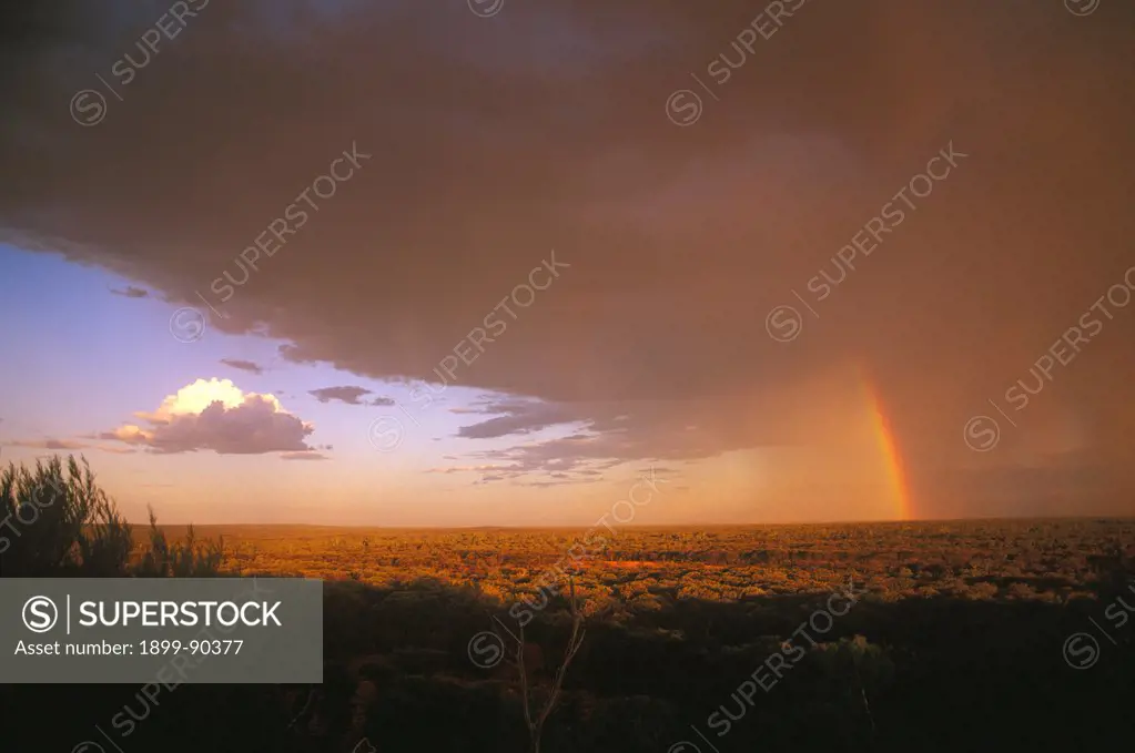 Thunderstorm across semi-arid plains of dry woodland, with rainbow extending through cloud, rain following dust storm, Welford (Barcoo) National Park, southwestern Queensland, Australia. 01/11/2001