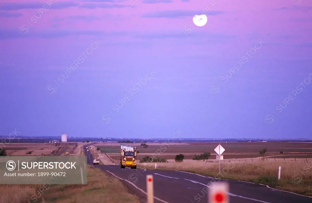 Road transport along a highway, an infrastructure corridor with road and rail linking provincial centres on productive agricultural country, Warrego Highway, Roma, Queensland, Australia. 01/11/2003