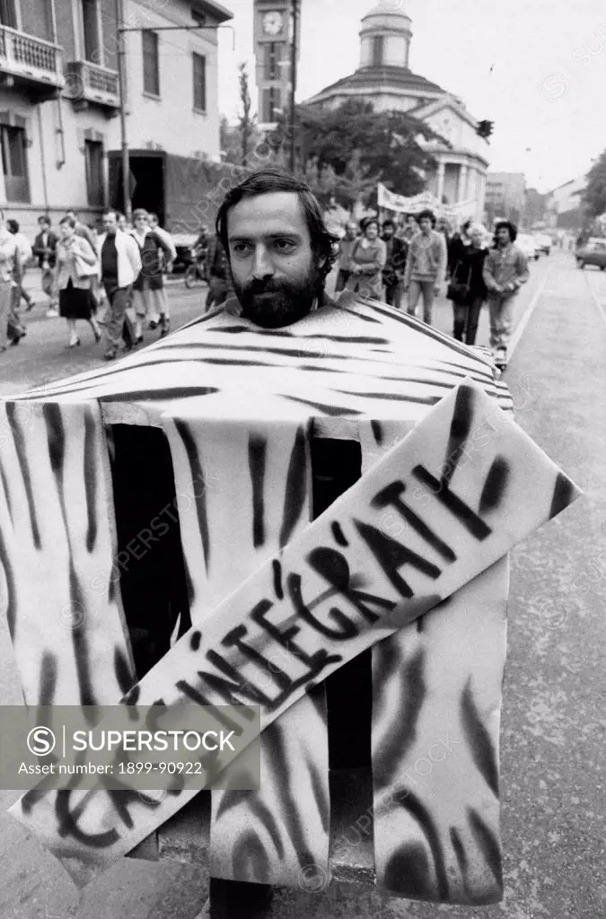 A demonstrator walking in the middle of the street; he is wearing a sort of cardboard box bearing the inscription Temporary lay-off: the Michelin company has just put some of its employees on a temporary lay-off scheme. Turin (Italy), 1984.