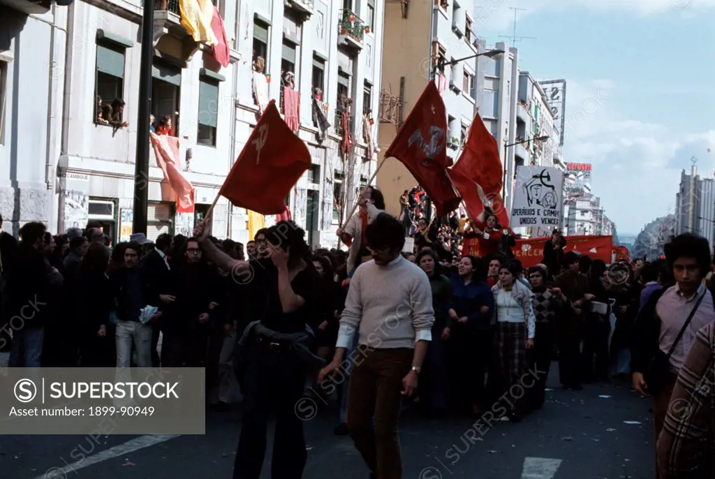 Demonstration of communist workers, representing the MRPP (Movimento Reorganizativo do Partido do Proletariado), the political Maoist party founded in 1970 in Portugal, along the streets of the capital city of Portugal; some red flags representing the symbol of the communist party can be seen clearly. Lisbon (Portugal), 1974.