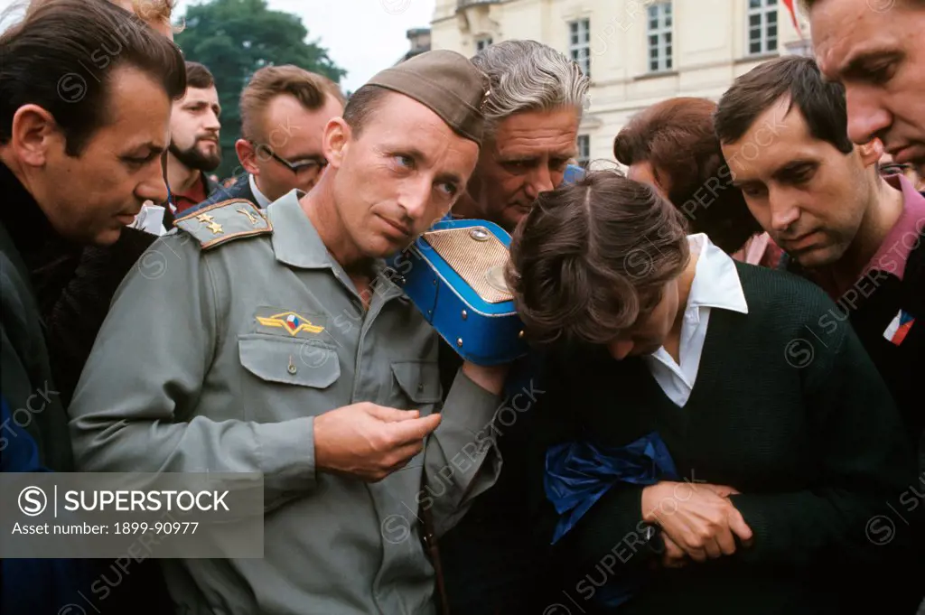 A Czech official surrounded by a crowd, listens to a pirate radio. Prague, August 1968.