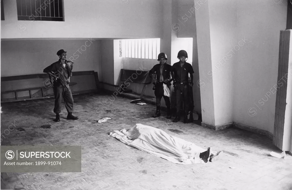 Three Vietnamese soldiers are standing in a big room. In front of them a dead body covered by a sheet. War in Vietnam (1960-1975). Saigon (Vietnam), 1968.