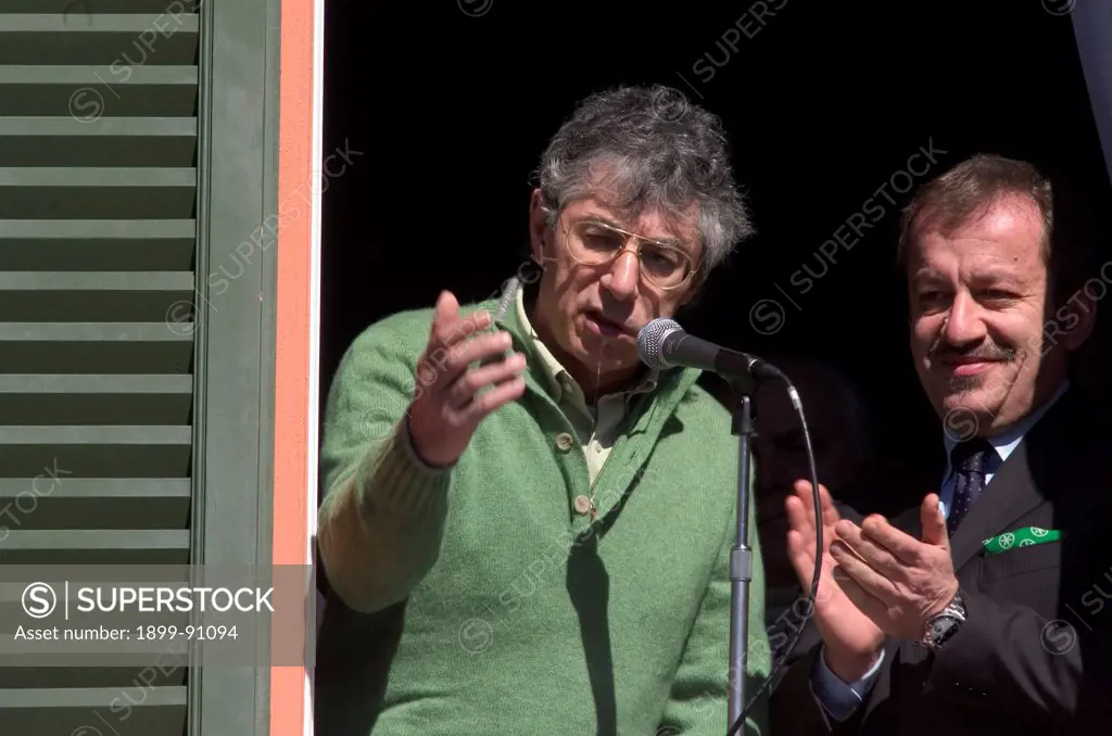 The leader of the Northern League party (Lega Nord), Umberto Bossi, is appearing at a window next to the Secretary of the party Roberto Maroni and is speaking at a microphone. Italy, 2005.