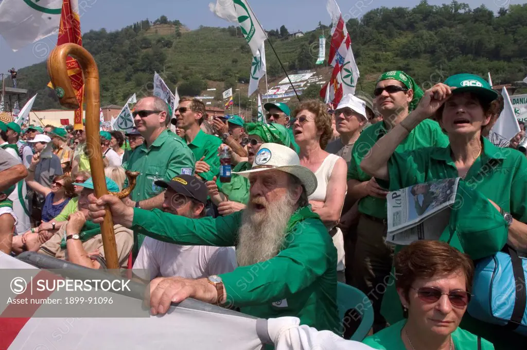 A group of supporters of the Northern League party (Lega Nord), wearing green shirts at a Northern League party meeting. In the close-up an old man with a hat, white beard and walking stick. Pontida (BG), Italy, 2005.