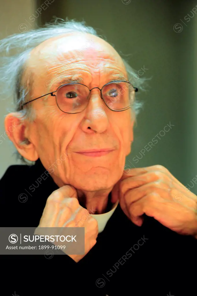Don Andrea Gallo, with eyeglasses, is arranging his clerical collar. Italy, 2012.