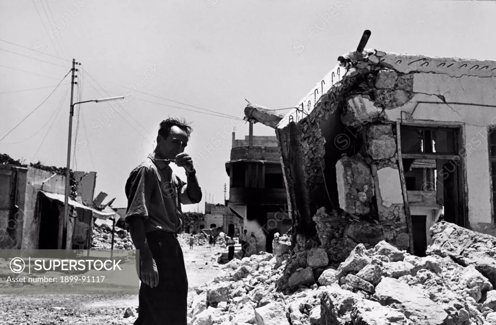 Paul Gauthier french catholic theologian walking among the ruins of the destroyed houses of the palestinian town of Qalqilya after the israeli attack , during the Arab-Israeli war called ""Six-Day War"". Paul Gauthier founded in Nazareth in 1958 the ""The companions of Jesus the carpenter,"" becoming a worker-priest. Qalqilya, State of Palestine, 1967