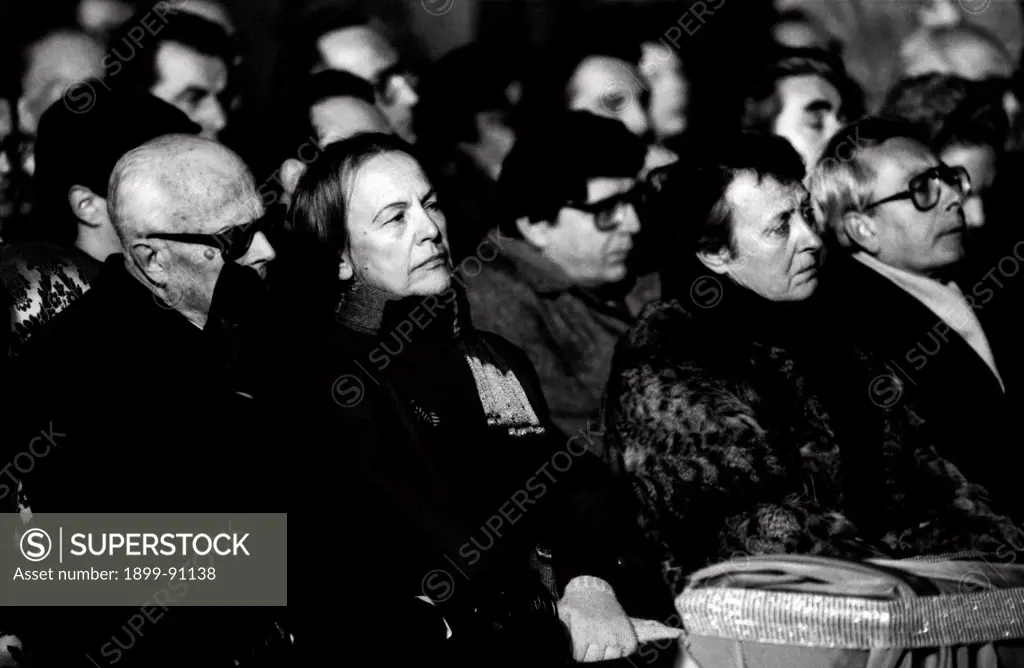 President of Italy Sandro Pertini and President of the Chamber of Deputies Nilde Iotti are seated close on the benches of a crowded church during a funeral; to the right are the italian politics Arnaldo Forlani and Vincenzo Scotti. Italy, 1985.