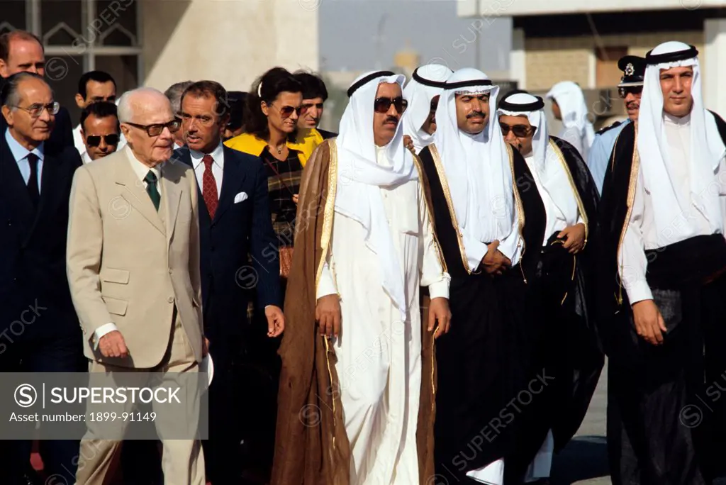 The President of Italy Sandro Pertini, during his diplomatic tour in the Far East, makes a stopover in Kuwait, just landed with italian Minister of Foreign Affairs Emilio Colombo; they're accompanied by Kuwait delegates on the airport runway. Kuwait, September 1980.