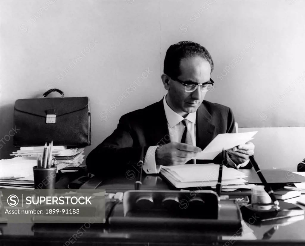The honourable Emilio Colombo, a leading figure of the Christian democrats and minister of Industry, is sitting at his desk, reading a sheet. Italy, 1962.