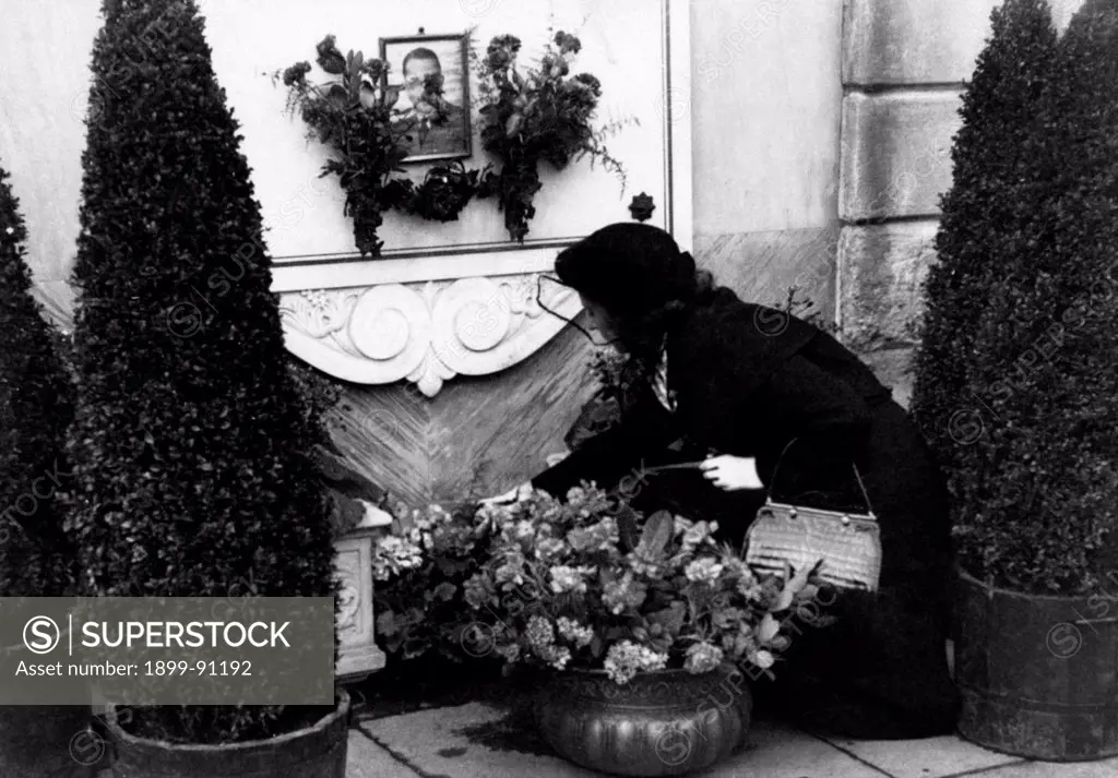 Lilian Sacchi takes some flowers to the tomb of her husband Carlo, shot dead with a 9mm caliber revolver by his lover, Pia Bellentani, on the 15th September 1948. Como (Italy).