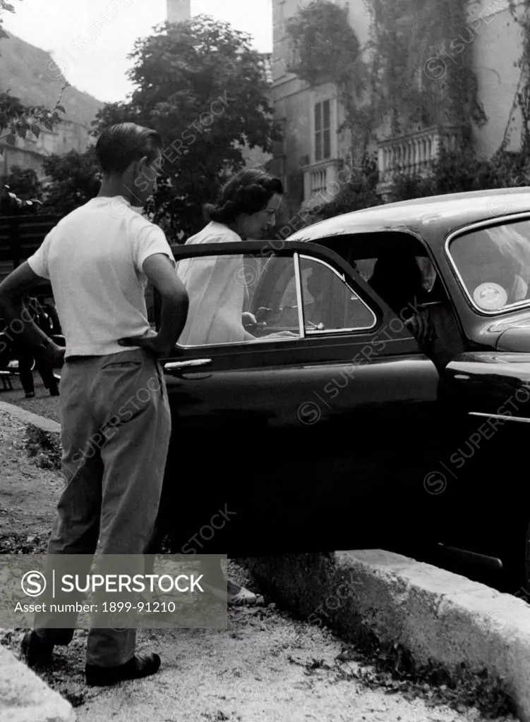 The Countess Pia Bellentani gets into a car to go to Rocca Pia; She is coming out from the psychiatric hospital where she was imprisoned for the murder of her lover Carlo sacchi with a shot from a 9mm caliber revolver. Pozzuoli (NA), Italy, August 1955.
