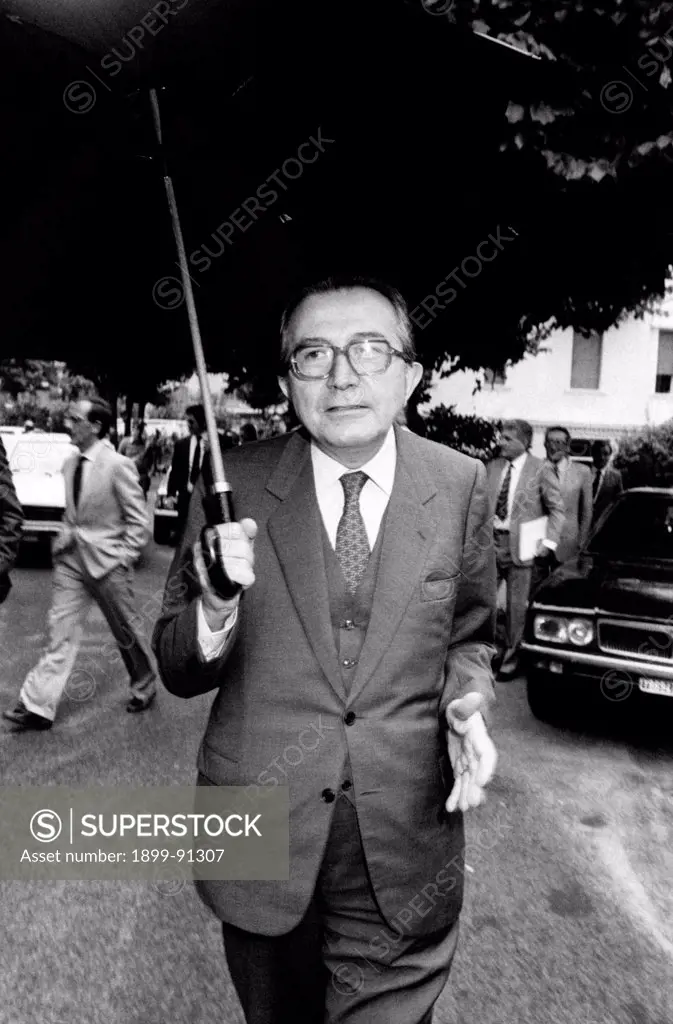 Italian journalist and Minister of Foreign Affairs of the Italian Republic Giulio Andreotti walking under an umbrella. Fiuggi, 1983