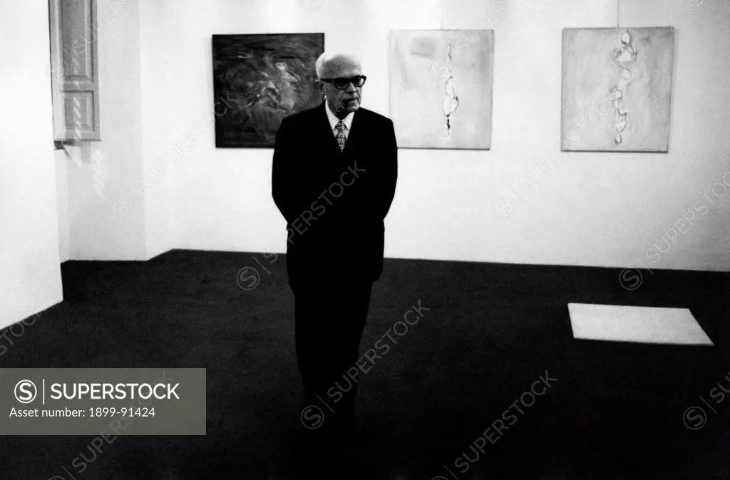 President of the Chamber of Deputies of the Italian Republic Sandro Pertini visiting a painting exhibition. Behind him, three paintings of the exhibition. 1972
