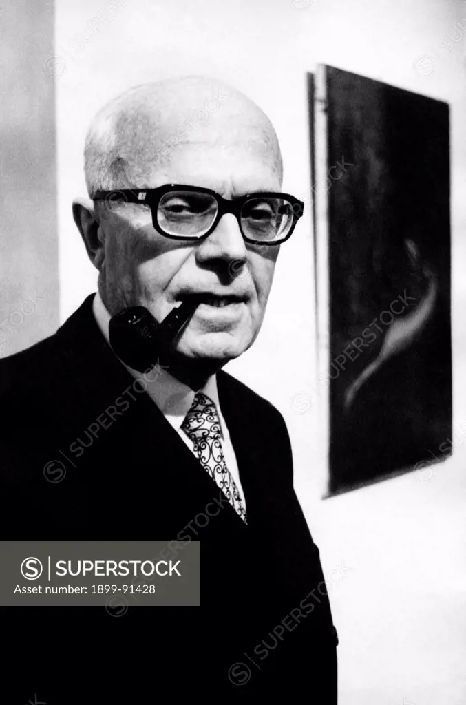 President of the Chamber of Deputies of the Italian Republic Sandro Pertini visiting a painting exhibition with a pipe in his mouth. Behind him, a painting of the exhibition. 1972