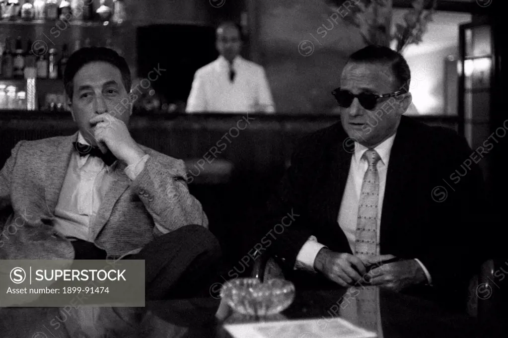 American journalist Victor Riesel sitting with a man. The journalist is blind because of a stream of vitriol. Venice, August 1957