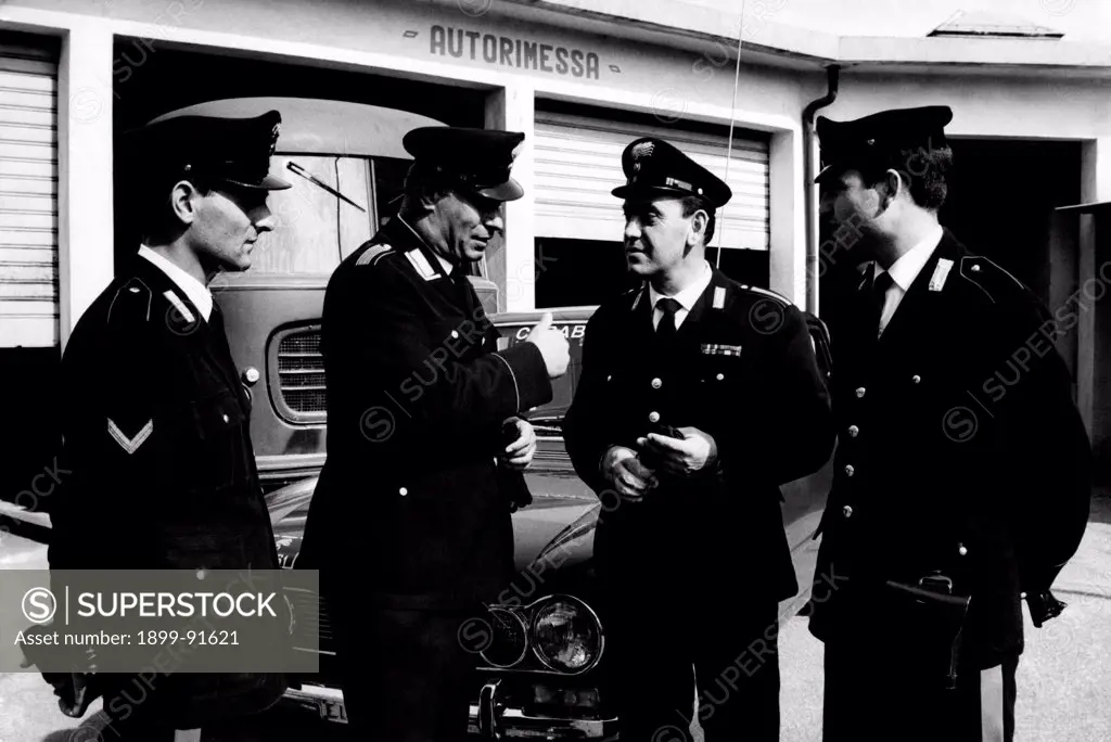 The carabinieri Giuseppe Giordano and Luigi Morabito and the marshals Domenico Colli and Nicola Sganga chatting in front af a garage. The four soldiers took part in the arrest of the Italian robbers and members of the Banda Cavallero Pietro Cavallero and Sante Notarnicola. 1967