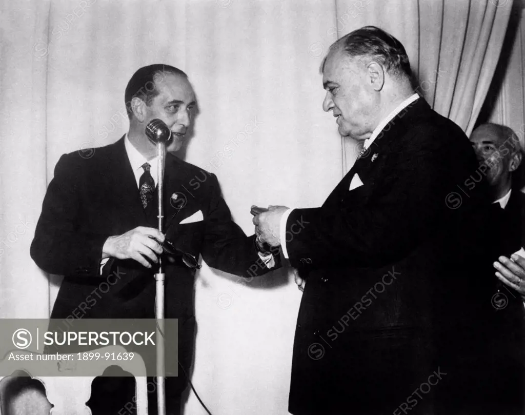 Italian Christian Democrat deputy and Minister of the Mercantile Marine of the Italian Republic Fernando Tambroni giving a gold medal to Italian tenor and actor Beniamino Gigli for his 40 years of artistic activities. Rome, 23rd December 1954