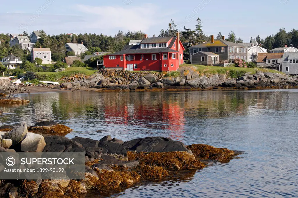 Maine coast Monhegan Island New England USA remote offshore harbor scene rocky coast red house.