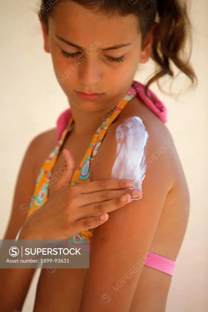 Girl putting on sunblock, Italy,08/11/2009