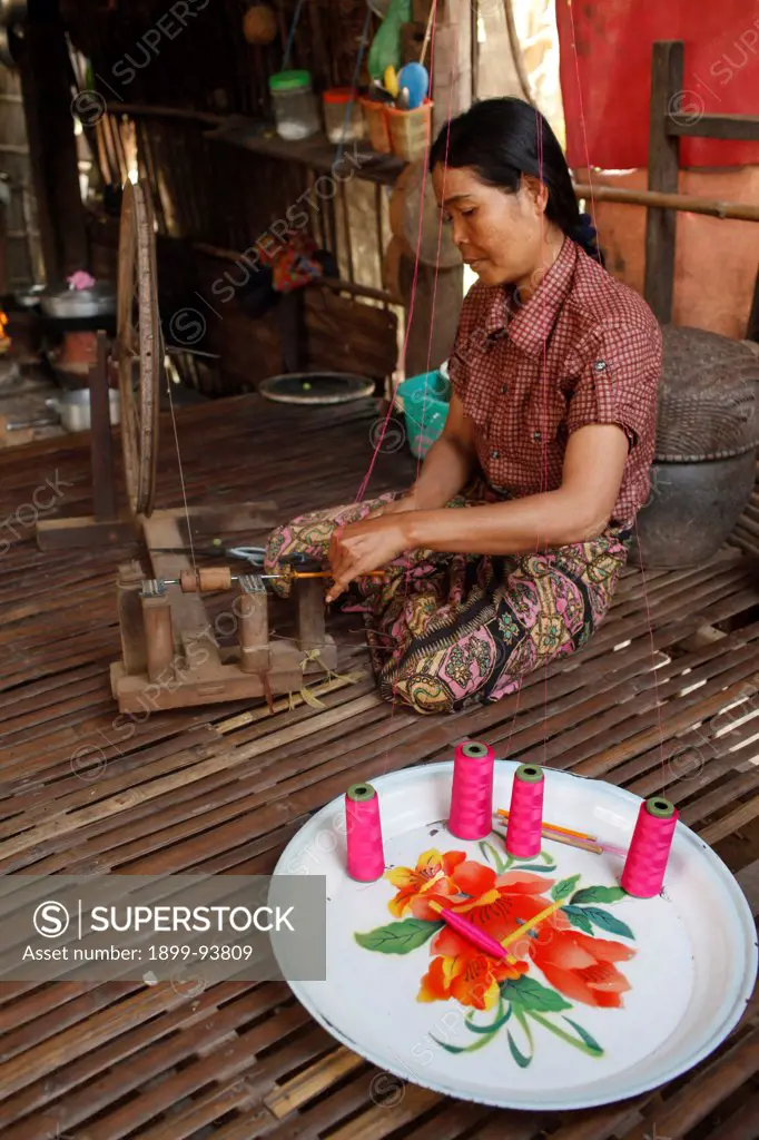 Microfinance client spinning silk in her home on Koh Dach (silk island), Prak Iva village, Prak Takoy district, Cambodia,02/17/2011