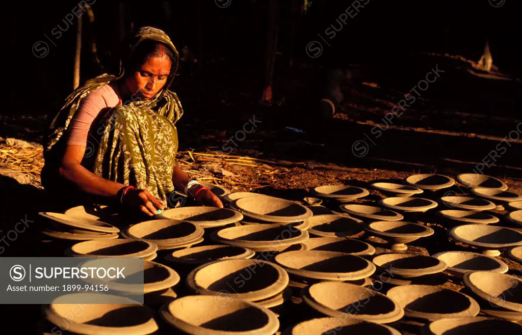 Woman polishing pots, Bangladesh.,07/16/2002