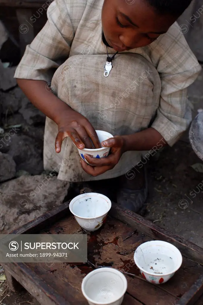 Domestic servant washing coffee cups , Lalibela, Ethiopia.,02/04/2010
