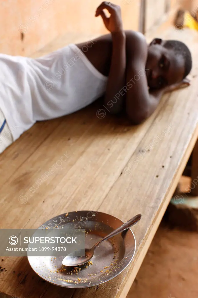 Young african boy and an empty plate, Lome, Togo.,06/26/2010