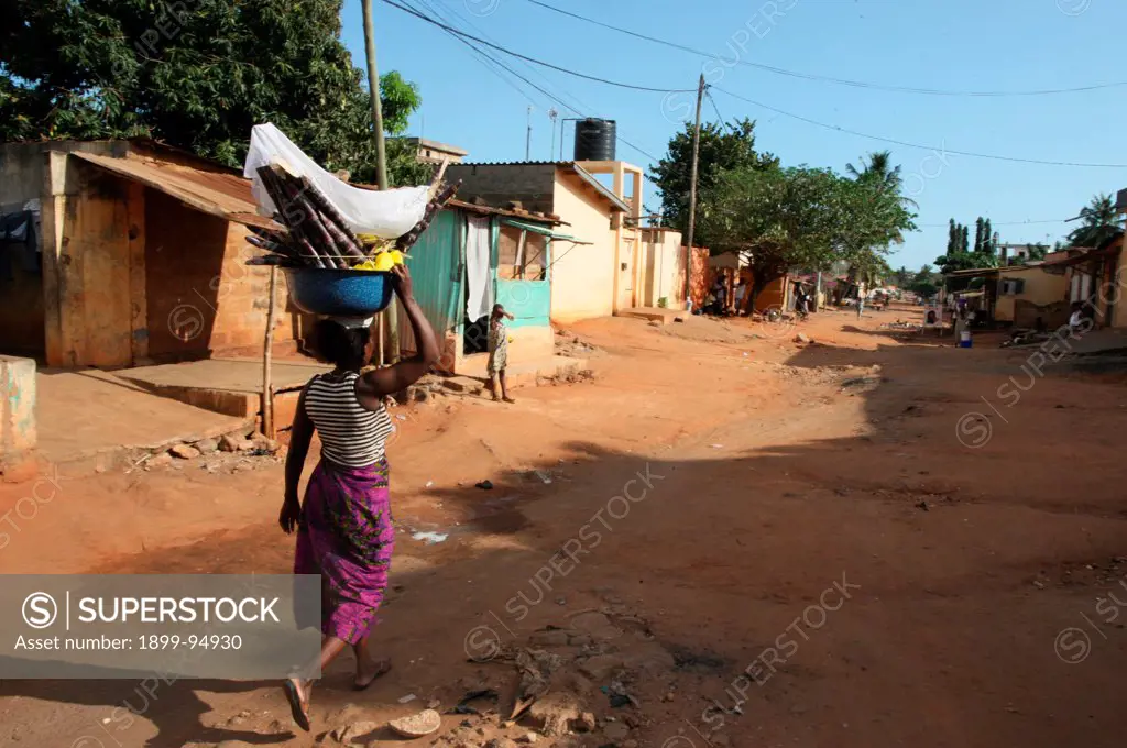 African woman carrying a bucket on her head, Lome, Togo.,10/16/2011