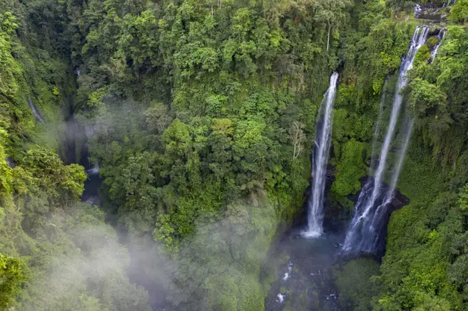 Huge Sekumpul water fall in dense tropical rainforest on the island of Bali, Indonesia, surrounded by mist