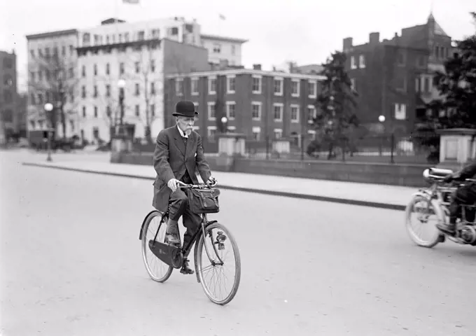 Old man riding his bicycle to work circa 1914. 