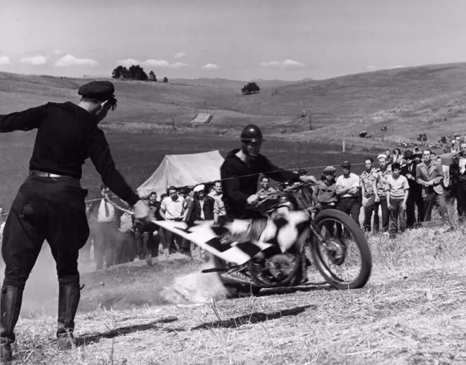 Santa Clara County, April 5, 1940 - Breaking the starting tape at the beginning of the Motorcycle Hill Climb.