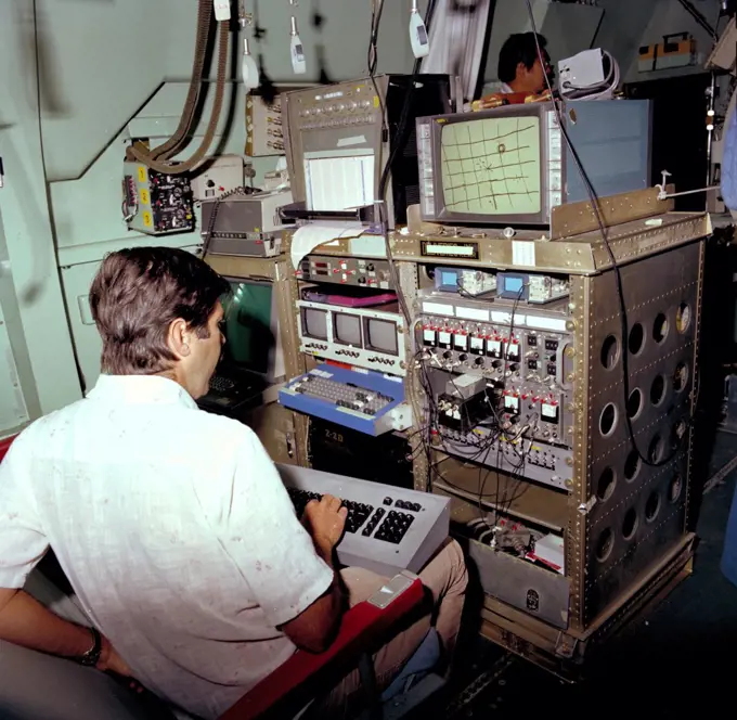 Astronomer at C-141 KAO workstation (rack) during flight of Harper Flange package ca. 1979. 
