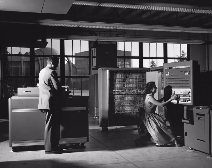 1958 - Electronic Machine Computing Branch, 704 computing lab; (left - right) William A Mersman and Marcelline K Chartz (aka - Marcie Smith) with IBM 704 Data Processor. 