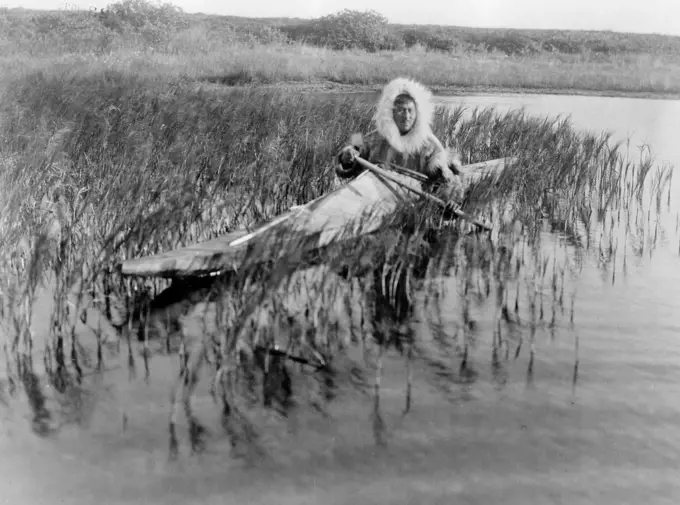 Edward S. Curits Native American Indians -  Kotzebue man paddles kayak through marsh in search of muskrats ca. 1929. 