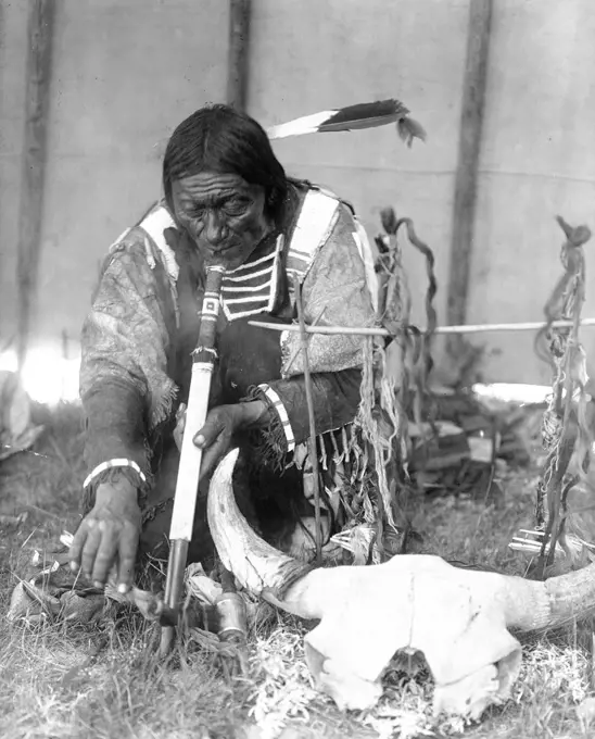 Edward S. Curtis Native American Indians - Dakota man with calumet kneeling by altar inside tipi ca. 1907. 