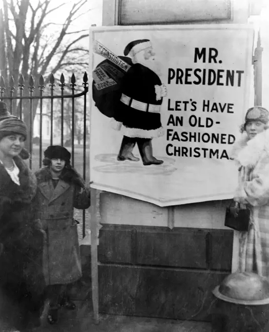 The demonstrators' sign says, 'Mr. President, let's have an old-fashioned Christmas,' and shows Santa Claus carrying a bag of gifts including, the Constitution, Free Assemblage, Free Speech, and Free Press. 