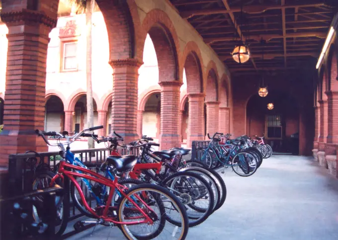 ca. 2004 -  Students at Flagler College chain their bicycles in an arched outdoor hallway before classes. 