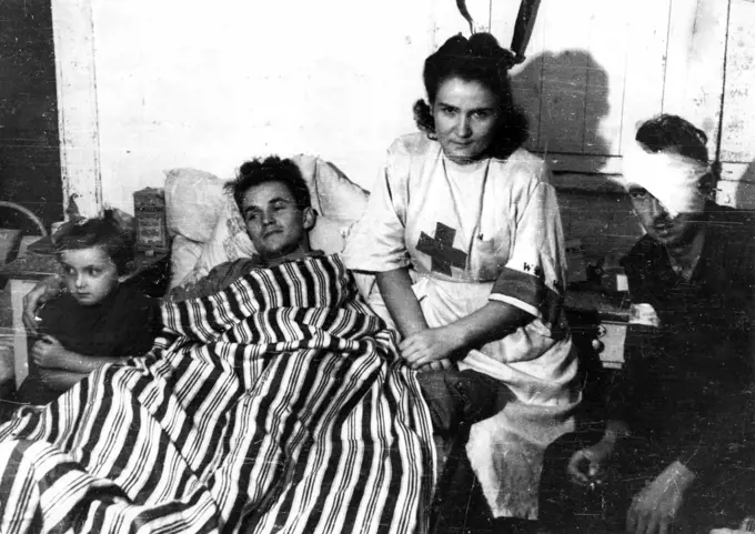 Warsaw Uprising: Nurse Janina Stczniewska 'Inka' with daughter Hania and wounded insurgent Edmund Michniewski 'Mi' in the hospital of 'Koszta' Company ca. August 1944. 