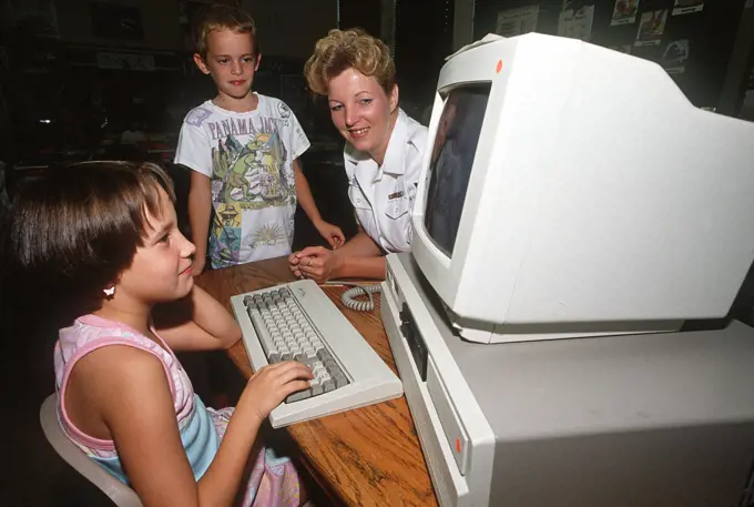 1989 - A Data Processing Technician explains a computer program to children from Warrington Middle School. . 