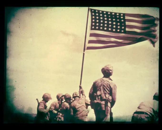 February 23, 1945, Iwo Jima - A still from the film shot by Marine photographer Bill Genaust of the flag-raising atop Mt. Suribachi.