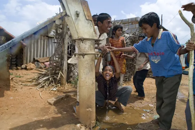 Children drinking from water pump. 