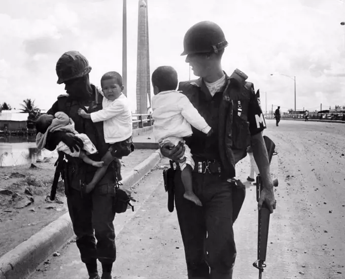Two American soldiers are carrying a newborn and two children in their arms. War in Vietnam (1960-1975). Saigon (Vietnam), 1968.