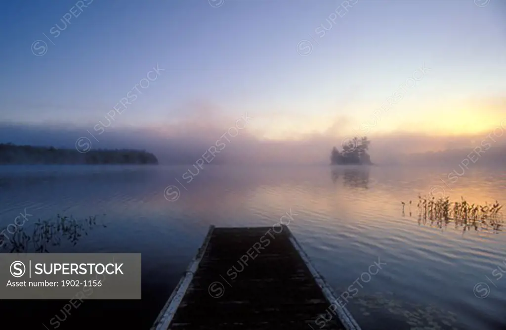 Canada Ontario Mackay Lake sunrise on lake with  wooden pier and island in distance