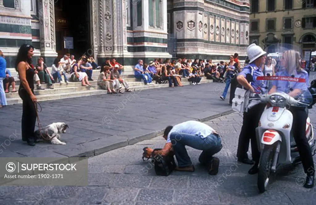 Italy Florence Cathedral of Santa Maria del Fiore The Duomo Piazza del Duomo tourist taking photos of girlfriend with dog