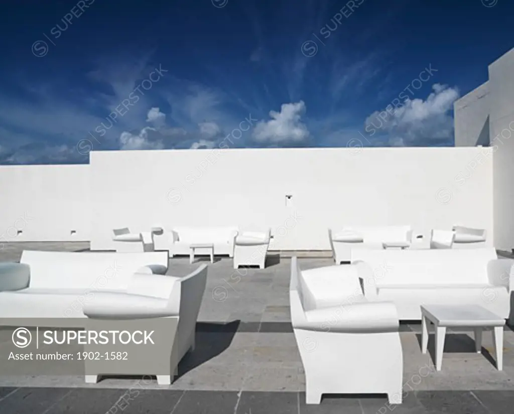 Mexico Quintana Roo Yucatan Peninsula Akumal Mayan Riviera white chairs and couches against a white wall and blue sky in a surreal setting