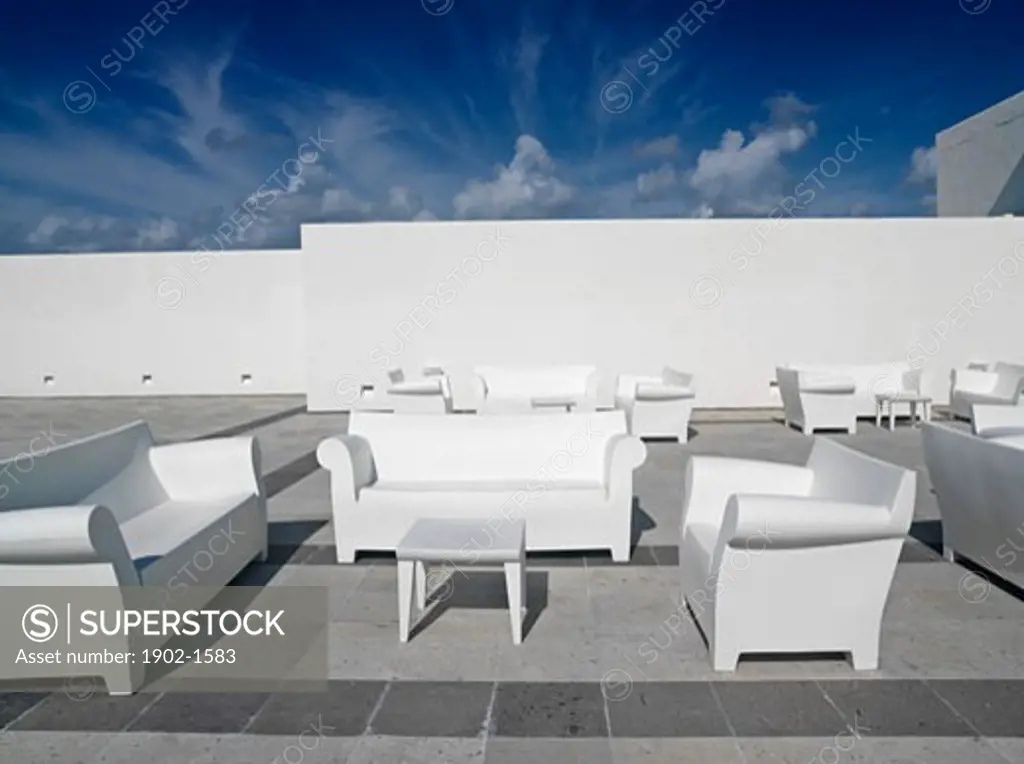 Mexico Quintana Roo Yucatan Akumal Mayan Riviera white chairs and couches against a white wall and blue sky in a surreal setting