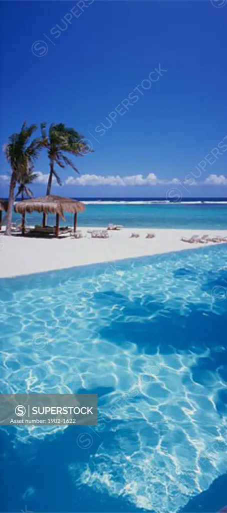 Mexico Quintana Roo Yucatan Peninsula Akumal Mayan Riviera palapas on beach by the sea with pool in foreground